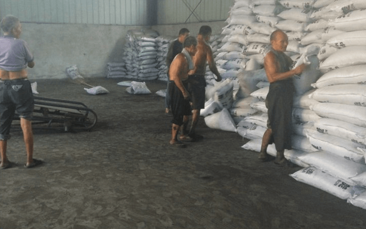 工人們把木質(zhì)<a href=http://www.yizhonglx.com/zzhxt/ target=_blank class=infotextkey>柱狀活性炭</a>裝袋，打包準備發(fā)車